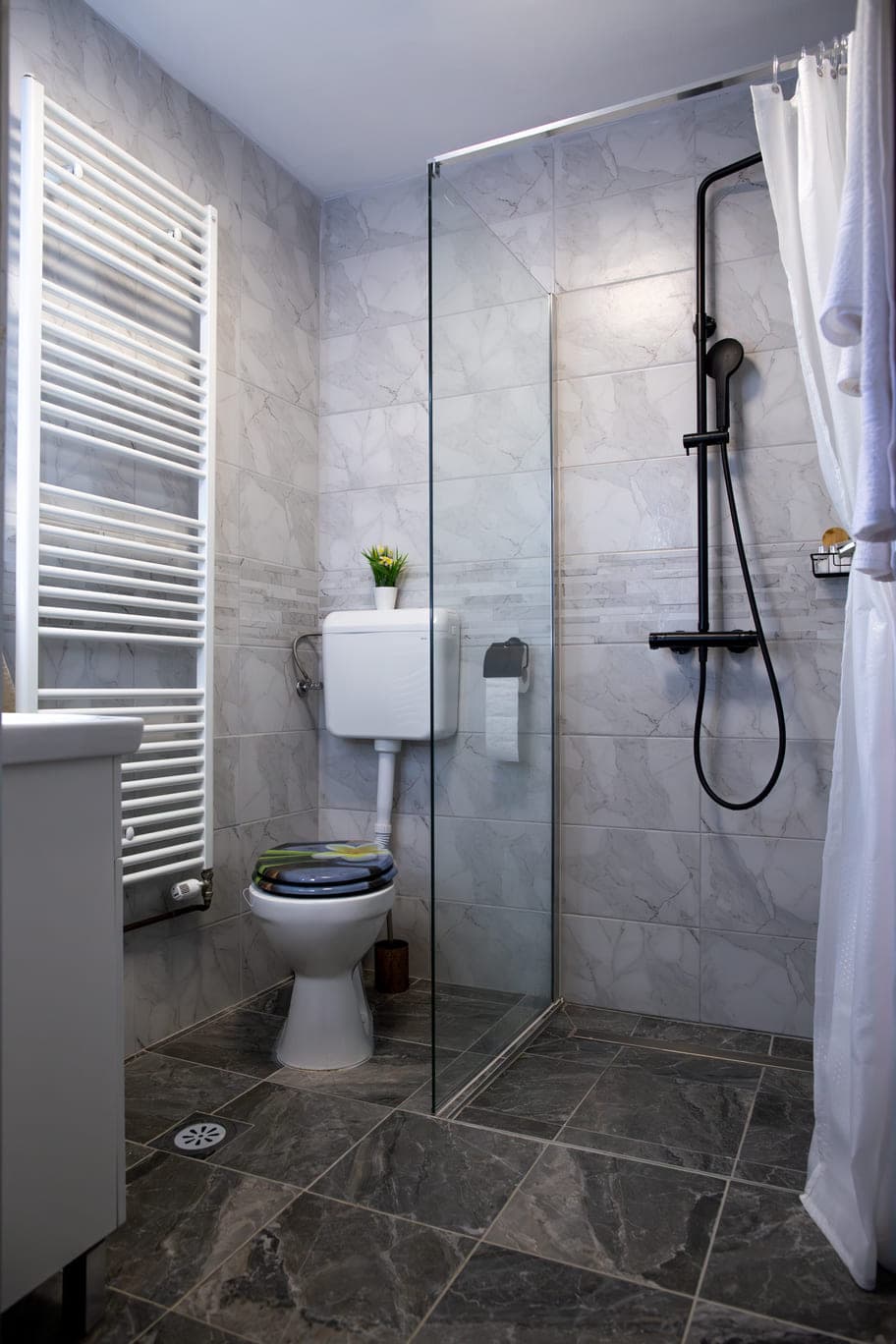 A modern bathroom showcasing a toilet, shower, and sink, emphasizing a sleek and organized space.