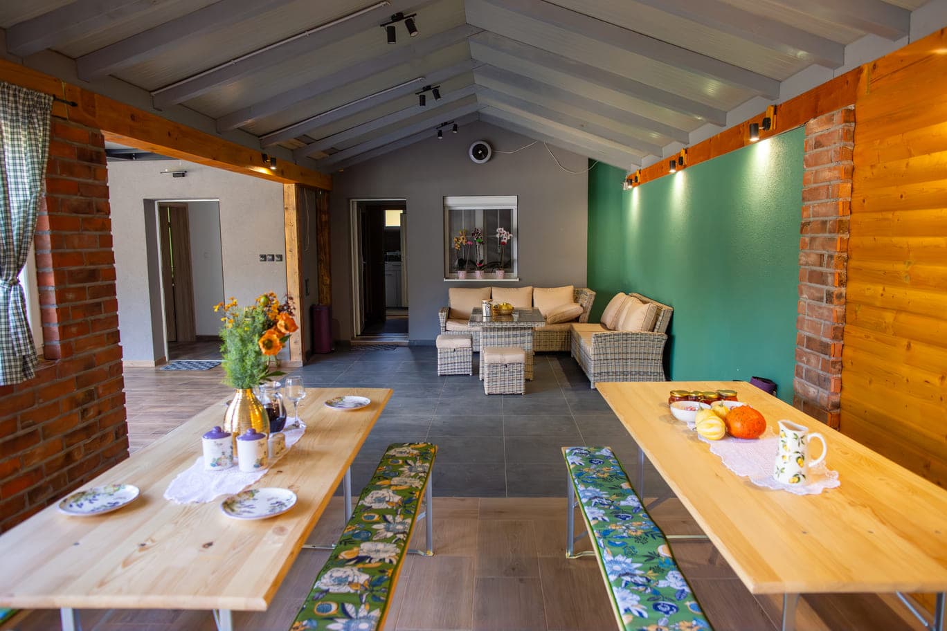 Sun room with tables and terrace furniture, creating a cozy setting for meals or socializing outside the house.